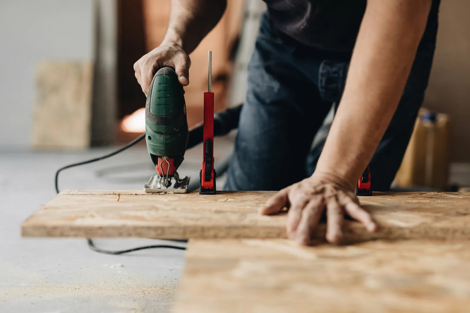 Carpenter cutting a board with a jigsaw