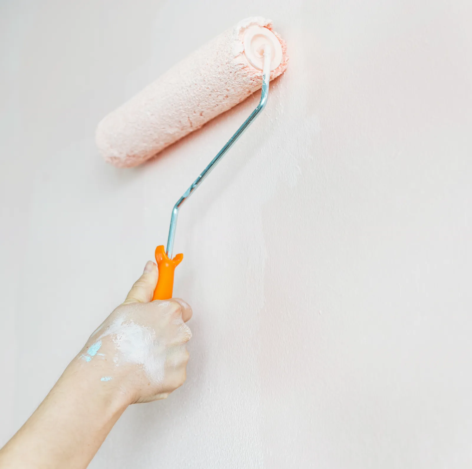 Paint roller applying a smooth coat to an interior wall